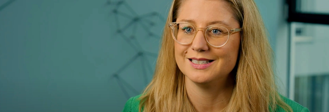 Smiling woman in glasses discussing professional growth through BeOne Careers.